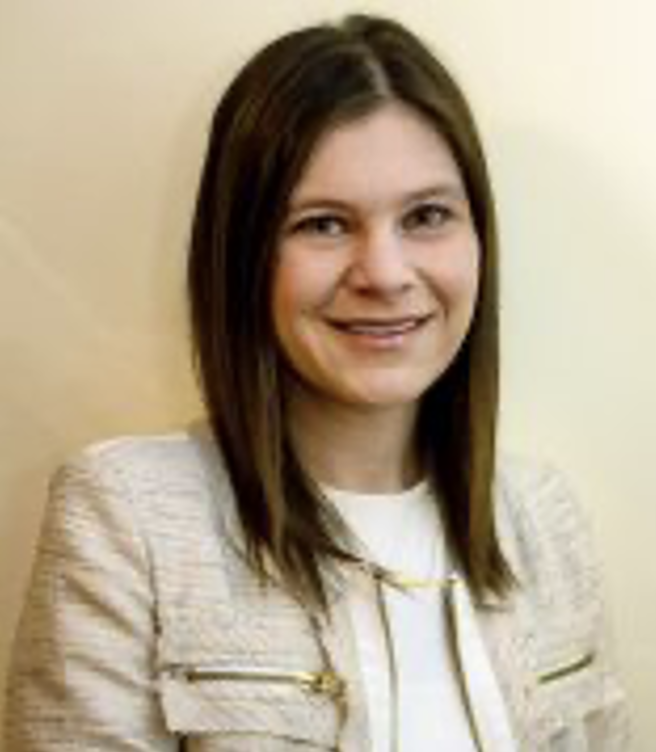 Headshot of Dr. Emily Gregori in a white shirt and beige jacket.