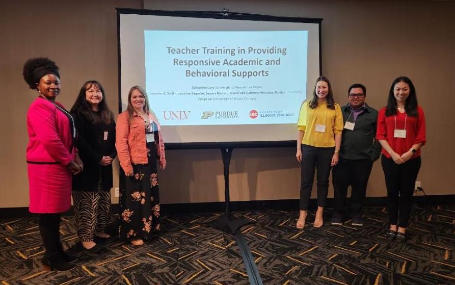 Six presenters standing next to their presentation screen titled "teacher training in providing responsive academic and behavioral supports"